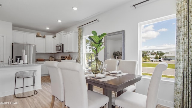 dining room with recessed lighting, light wood-style flooring, a wealth of natural light, and visible vents