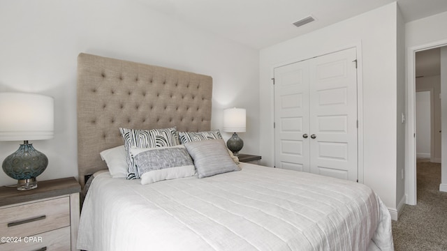 bedroom featuring a closet, carpet floors, visible vents, and baseboards