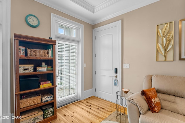 entryway with ornamental molding and wood finished floors
