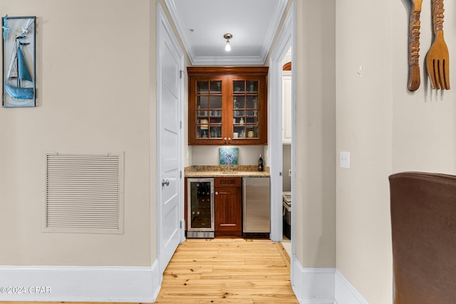 bar featuring light wood-type flooring, ornamental molding, visible vents, fridge, and beverage cooler