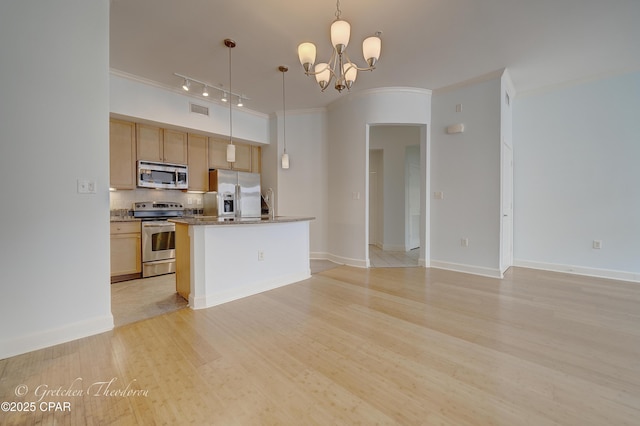 8700 Front Beach Rd Unit 5101, Panama City Beach, FL 32407 - kitchen with stainless steel appliances, a chandelier, track lighting, backsplash, and ornamental molding