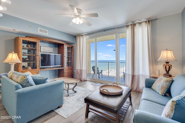 living room featuring visible vents, wood finished floors, and ceiling fan