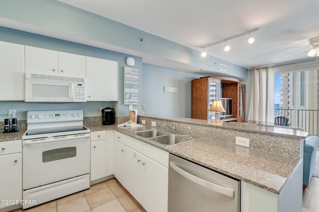 kitchen with white cabinetry, white appliances, light tile patterned floors, a sink, and a peninsula