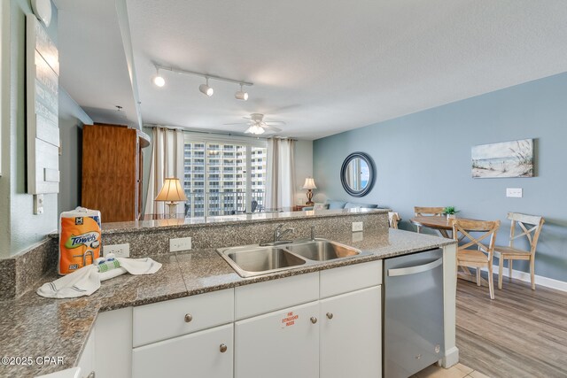 kitchen featuring a sink, dishwasher, light wood-type flooring, white cabinets, and ceiling fan