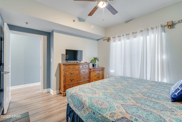 bedroom with light wood finished floors, baseboards, and a ceiling fan