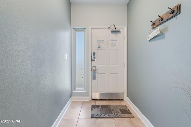 doorway to outside featuring light tile patterned floors and baseboards