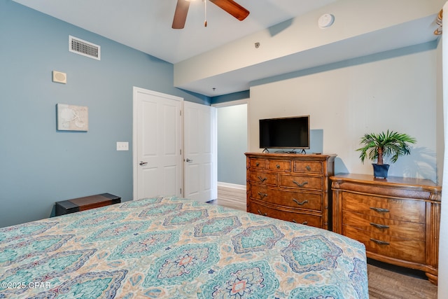 bedroom with visible vents, wood finished floors, and ceiling fan