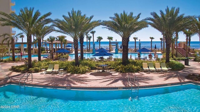 pool featuring a patio and a water view