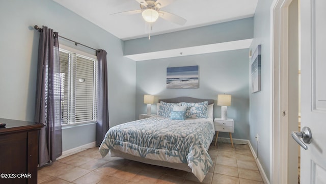 tiled bedroom featuring a ceiling fan and baseboards