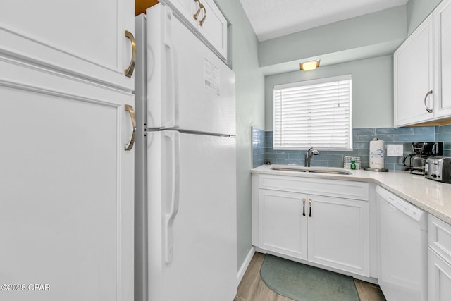 5801 Thomas Dr Unit 1216, Panama City Beach, FL 32408 - kitchen featuring white cabinetry, tasteful backsplash, a sink, light countertops, and white appliances