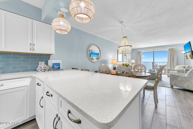 5801 Thomas Dr Unit 1216, Panama City Beach, FL 32408 - kitchen featuring tasteful backsplash, a peninsula, light stone counters, a textured ceiling, and open floor plan