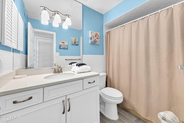 5801 Thomas Dr Unit 1216, Panama City Beach, FL 32408 - full bath with toilet, tile walls, wood finished floors, vanity, and wainscoting