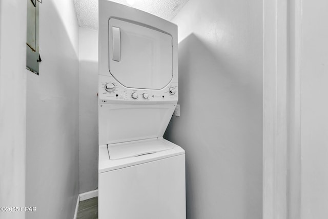 5801 Thomas Dr Unit 1216, Panama City Beach, FL 32408 - clothes washing area featuring stacked washer and clothes dryer, a textured ceiling, and laundry area