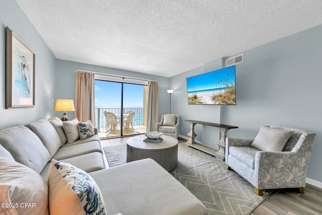 5801 Thomas Dr Unit 1216, Panama City Beach, FL 32408 - living area with a textured ceiling, visible vents, wood finished floors, and baseboards