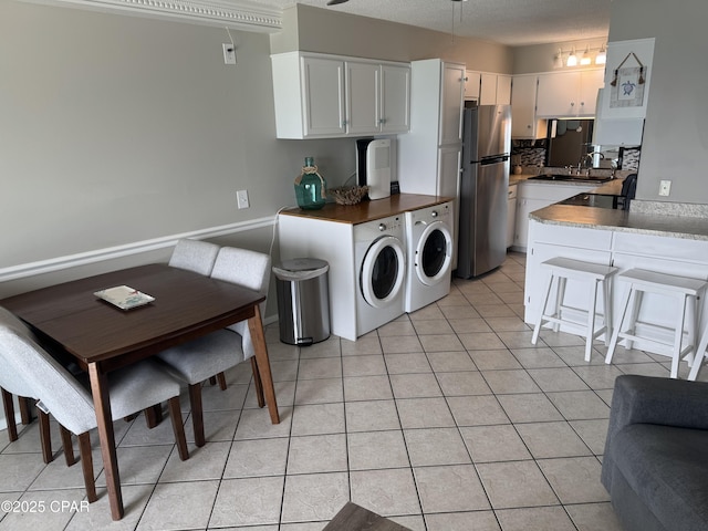8743 Thomas Dr Unit 1328, Panama City, FL 32408 - kitchen with white cabinets, a peninsula, separate washer and dryer, and freestanding refrigerator