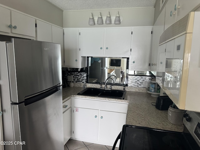 8743 Thomas Dr Unit 1328, Panama City, FL 32408 - kitchen featuring a sink, appliances with stainless steel finishes, a textured ceiling, tile patterned floors, and decorative backsplash