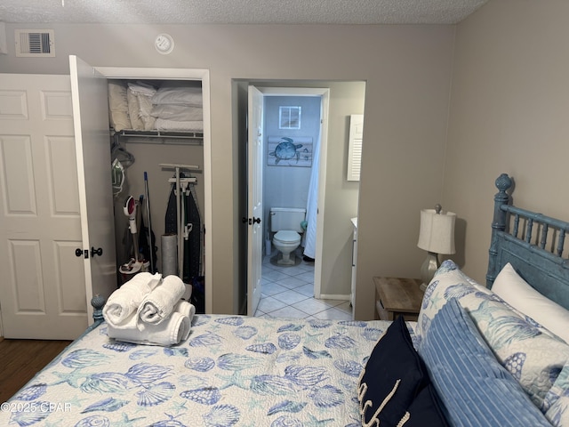 8743 Thomas Dr Unit 1328, Panama City, FL 32408 - tiled bedroom featuring a closet, ensuite bathroom, a spacious closet, and visible vents