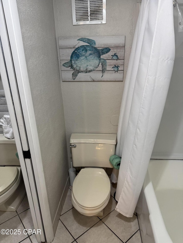 8743 Thomas Dr Unit 1328, Panama City, FL 32408 - full bath featuring tile patterned flooring, visible vents, toilet, shower / tub combo with curtain, and a textured wall
