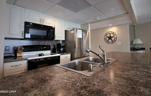 kitchen with black appliances, dark countertops, white cabinets, a sink, and tasteful backsplash