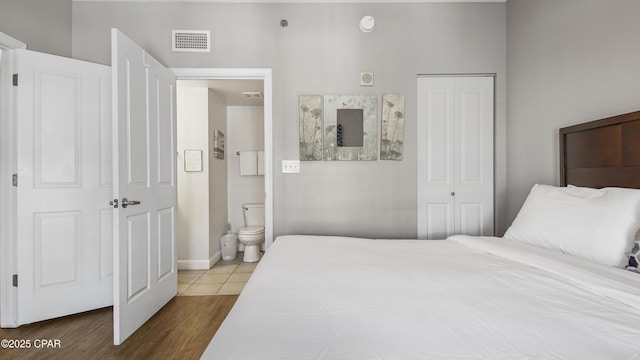 9900 S Thomas Dr Unit 1719, Panama City Beach, FL 32408 - bedroom featuring a closet, ensuite bath, and wood finished floors
