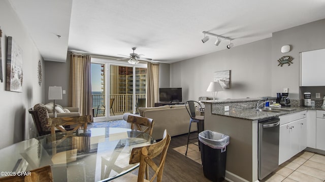 9900 S Thomas Dr Unit 1719, Panama City Beach, FL 32408 - kitchen with stainless steel dishwasher, a peninsula, open floor plan, white cabinetry, and ceiling fan