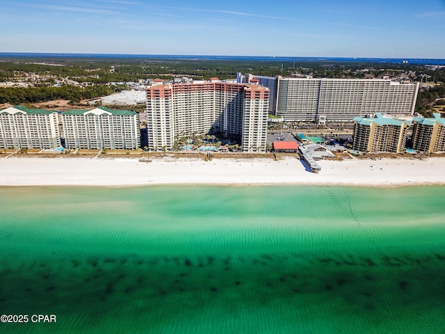 drone / aerial view with a water view, a view of the beach, and a city view