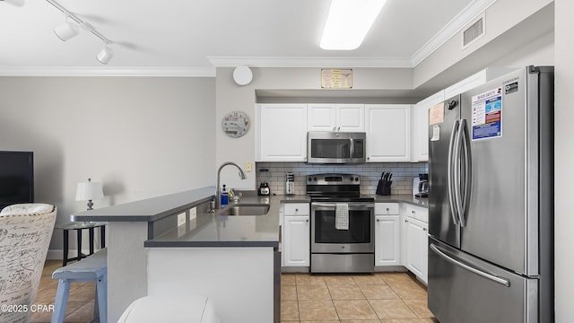kitchen featuring stainless steel appliances, a peninsula, ornamental molding, dark countertops, and light tile patterned floors