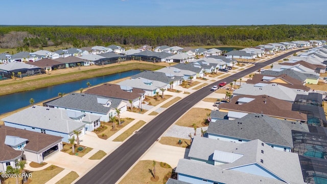 birds eye view of property with a water view, a view of trees, and a residential view