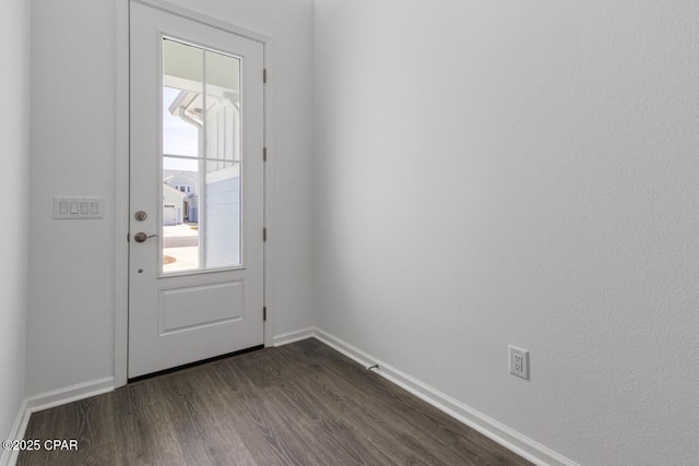 doorway to outside with dark wood-style flooring and baseboards