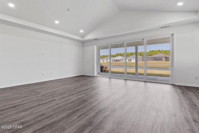 empty room featuring dark wood-style flooring, baseboards, recessed lighting, and vaulted ceiling