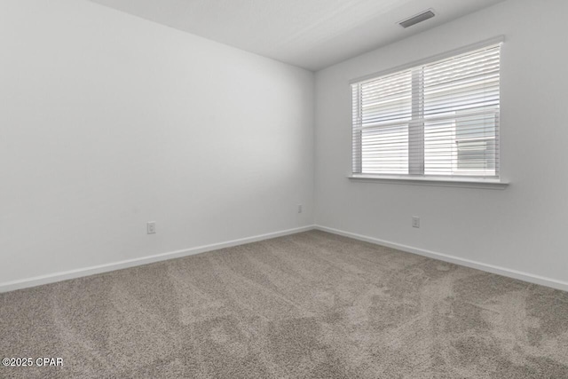 unfurnished room with visible vents, baseboards, and carpet