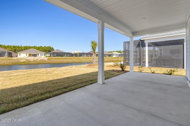 view of patio / terrace featuring a water view, glass enclosure, and a residential view