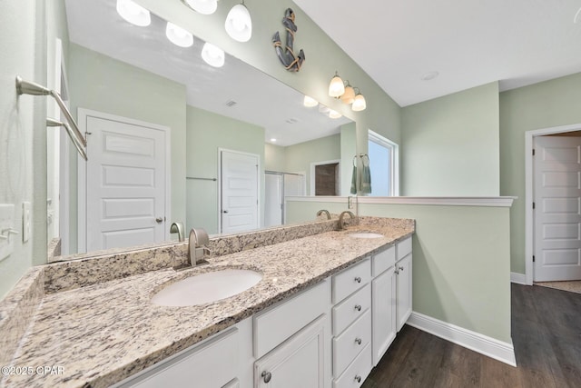 365 Confidence Way, Panama City, FL 32409 - full bathroom featuring wood finished floors, baseboards, double vanity, and a shower with door