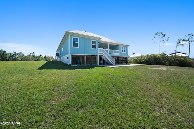 365 Confidence Way, Panama City, FL 32409 - rear view of house featuring stairs, board and batten siding, metal roof, a yard, and a sunroom