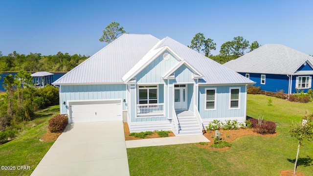 365 Confidence Way, Panama City, FL 32409 - view of front of home with an attached garage, a front lawn, a porch, metal roof, and driveway