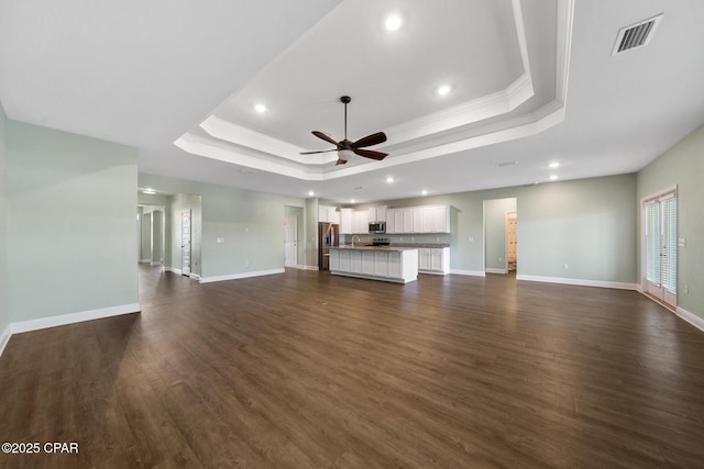 365 Confidence Way, Panama City, FL 32409 - unfurnished living room with a raised ceiling, ornamental molding, a ceiling fan, recessed lighting, and dark wood-type flooring