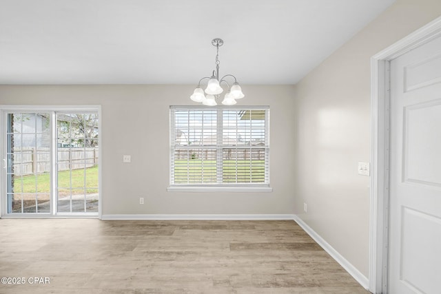 unfurnished dining area featuring baseboards, a chandelier, and light wood-style floors