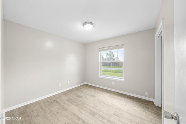 empty room featuring baseboards and light wood-style floors