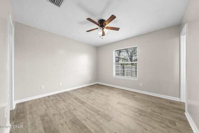 unfurnished room featuring wood finished floors, baseboards, ceiling fan, and visible vents