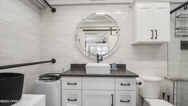 bathroom with vanity, tile walls, ceiling fan, backsplash, and toilet