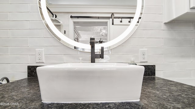 room details featuring decorative backsplash and a sink