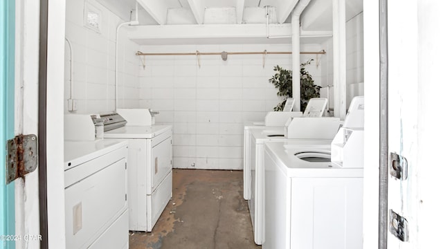 common laundry area with washing machine and dryer and tile walls