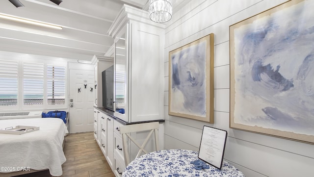 bedroom with wood finished floors and a notable chandelier