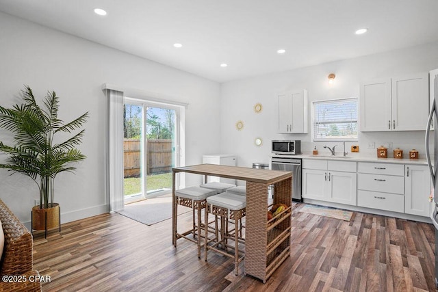 kitchen featuring appliances with stainless steel finishes, wood finished floors, and a healthy amount of sunlight