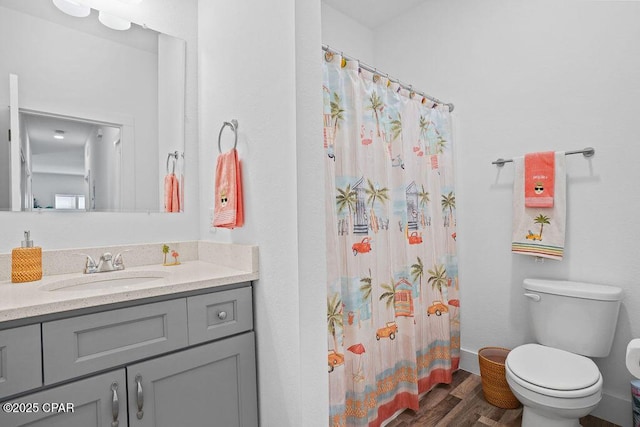 bathroom with vanity, a shower with curtain, toilet, and wood finished floors