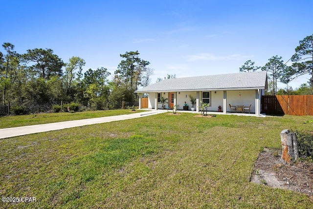 view of front of house with a front yard, fence, stucco siding, and concrete driveway