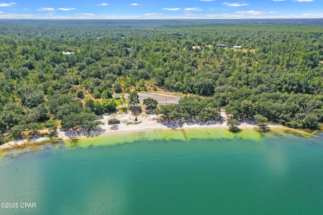 birds eye view of property featuring a wooded view and a water view
