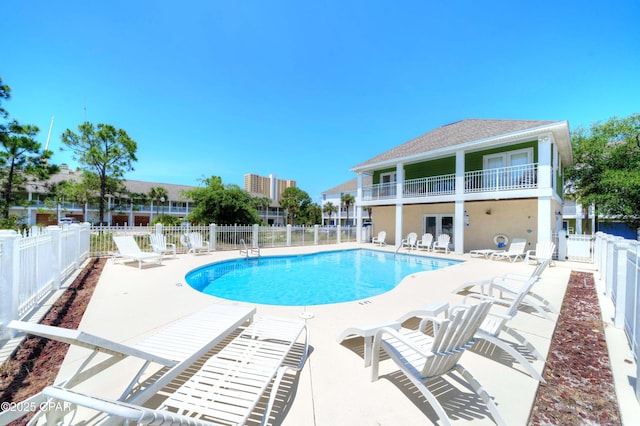 community pool featuring a fenced backyard and a patio area