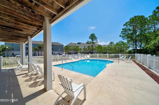 pool with a residential view, a patio, and fence