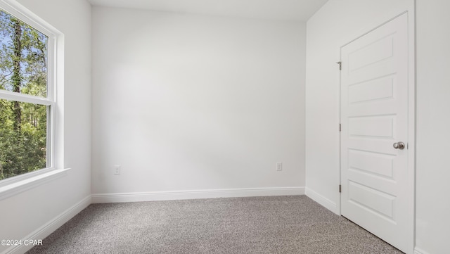 empty room featuring carpet floors and baseboards